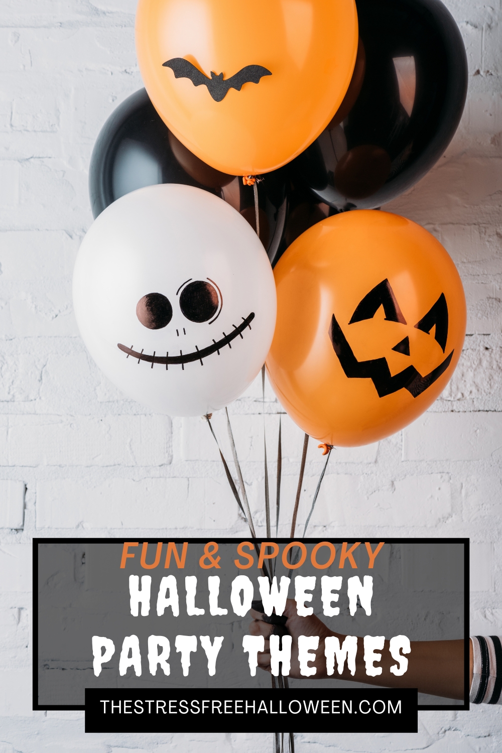 person's hand holding three halloween balloons with text overlay fun and spooky Halloween party themes