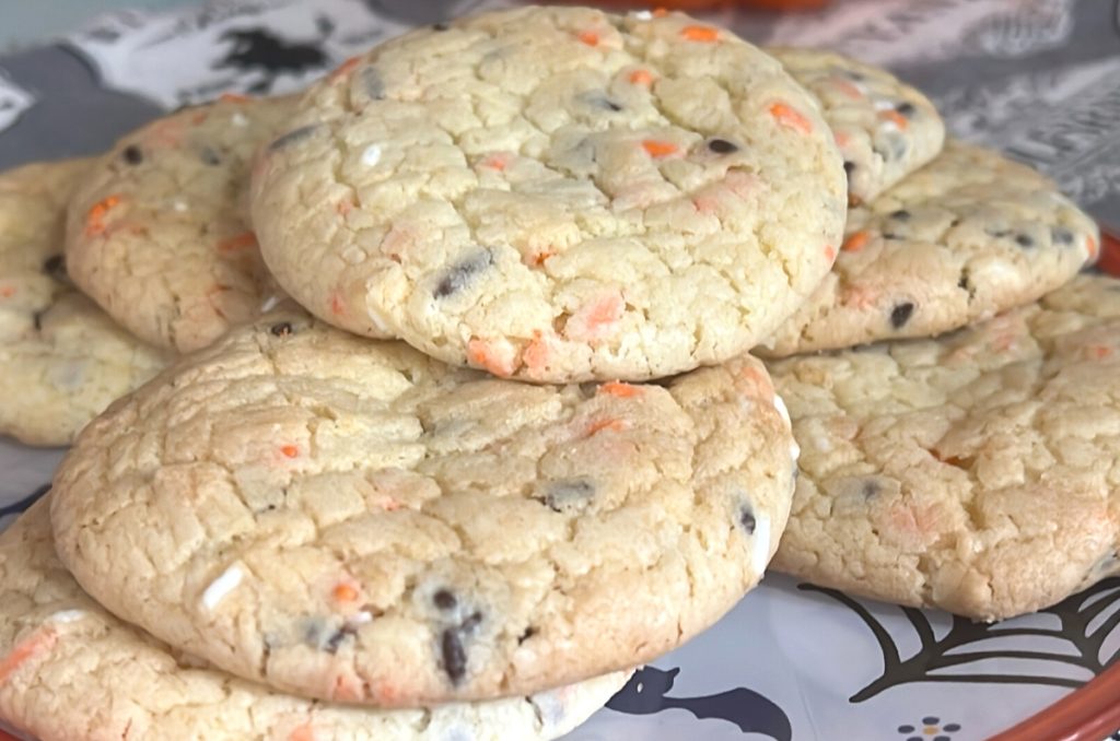 Halloween cookies with orange, black, and white sprinkles on Halloween plate