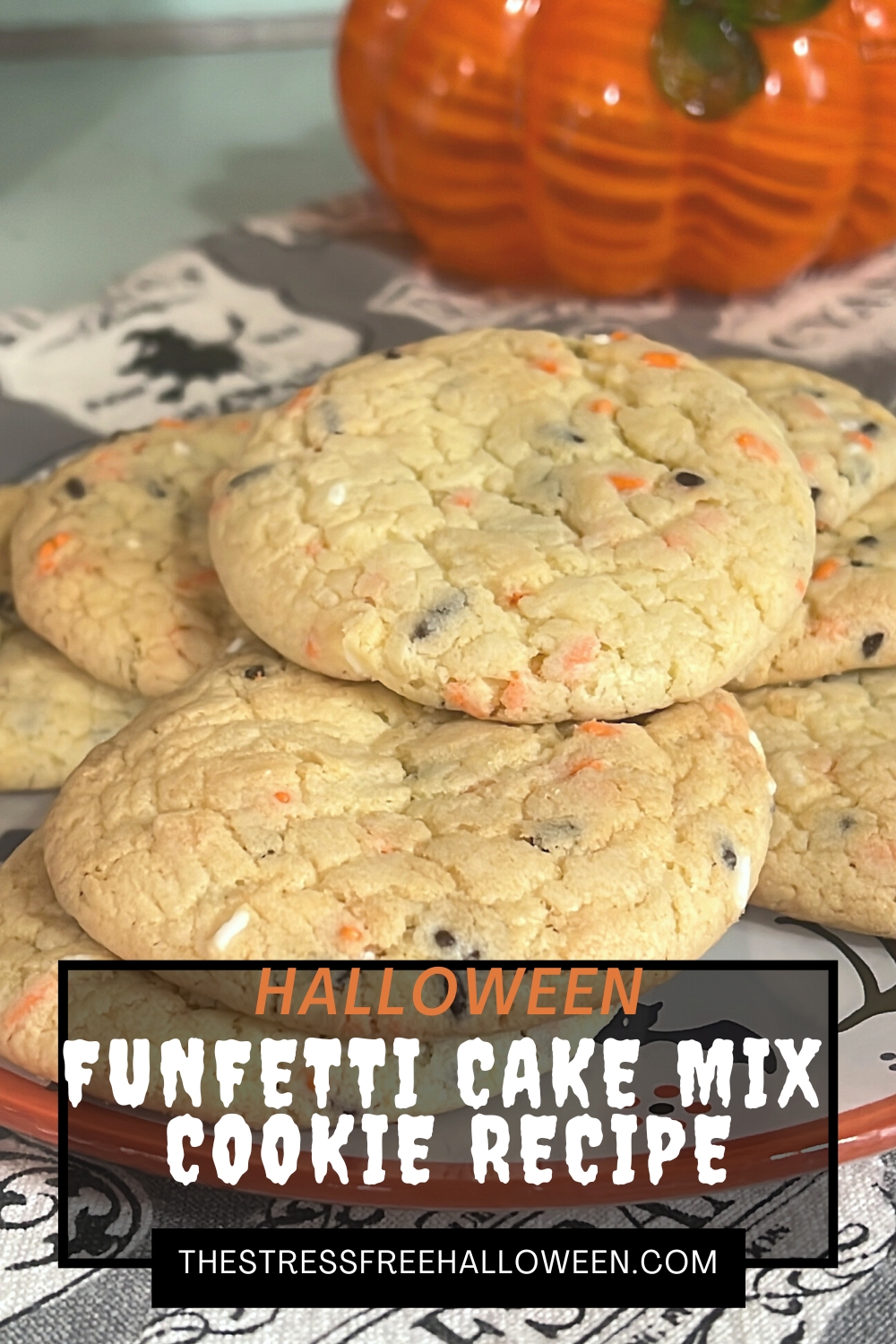 Cookies with orange, black, and white sprinkles on Halloween plate with glass pumpkin the background. Text overlay- Halloween Funfetti Cake Mix Cookie Recipe